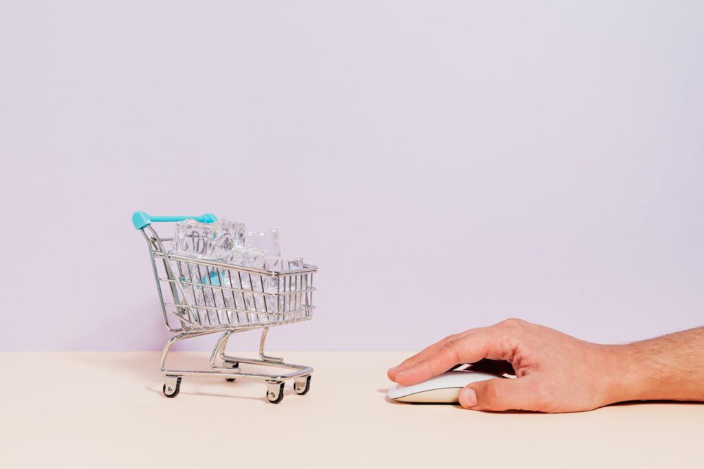 Shopping cart and hand with mouse representing PPC advertising concept