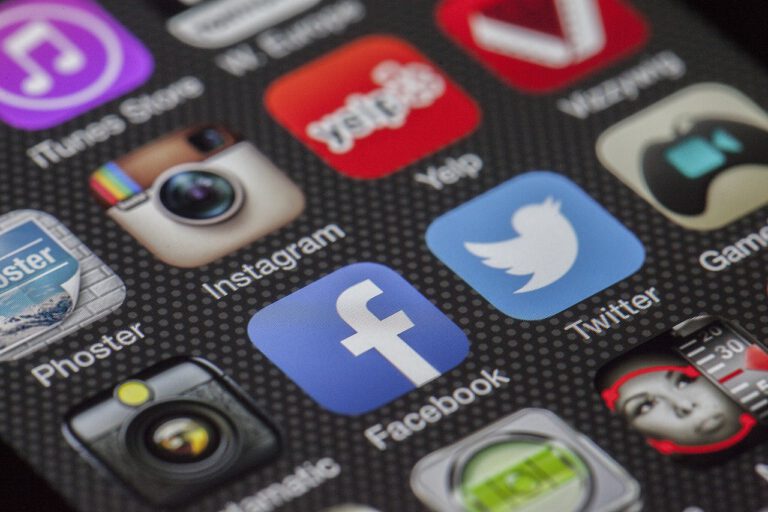 Close-up of social media app icons on a smartphone screen, including Facebook, Twitter, and Instagram.